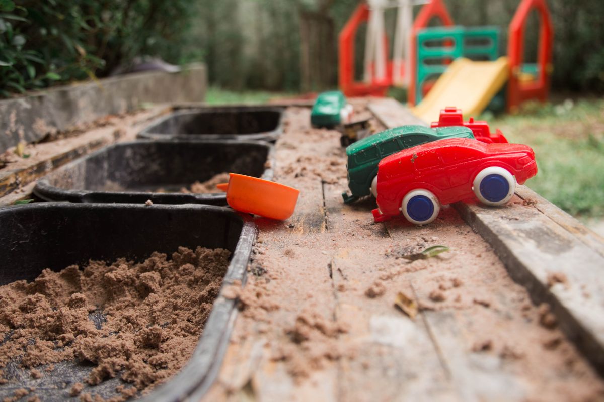 Outdoor-Spielbereich mit Sand, Behältern und Spielzeug im Garten